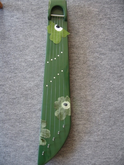 A five-string kantele painted green with Unikko as decoration.